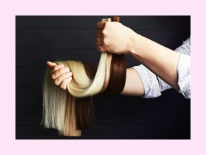 Customer is holding a variety of colored bulk hair extensions