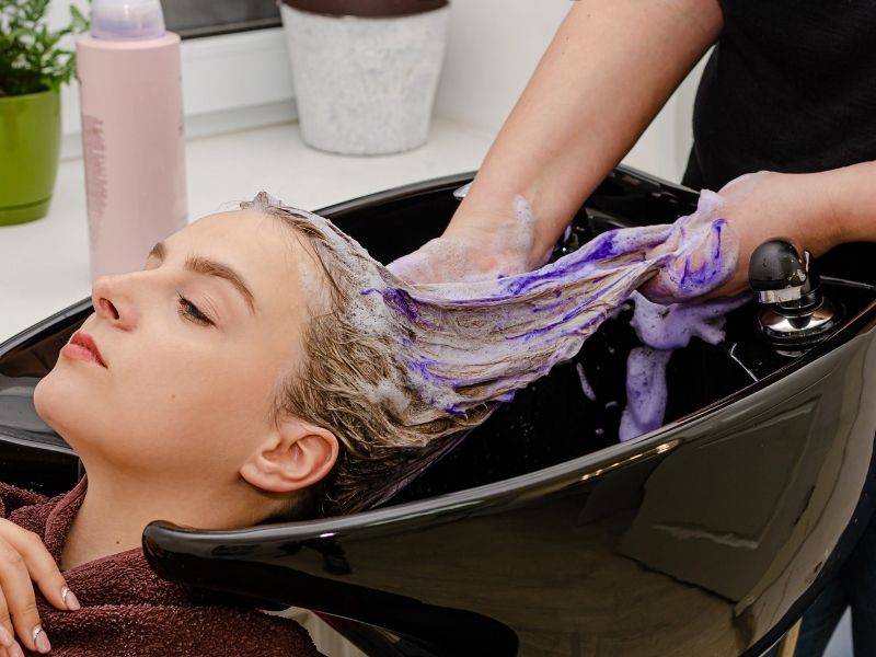 Using purple shampoo to fix uneven bleached hair 