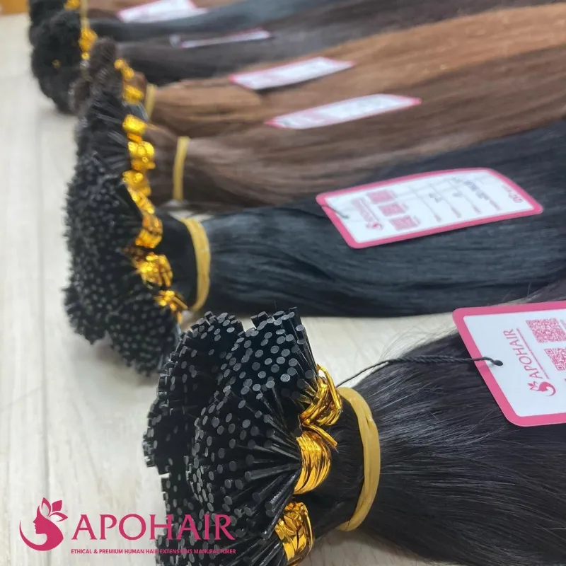 Close-up view of I-tip keratin hair extension bonds in basic colors at Apohair